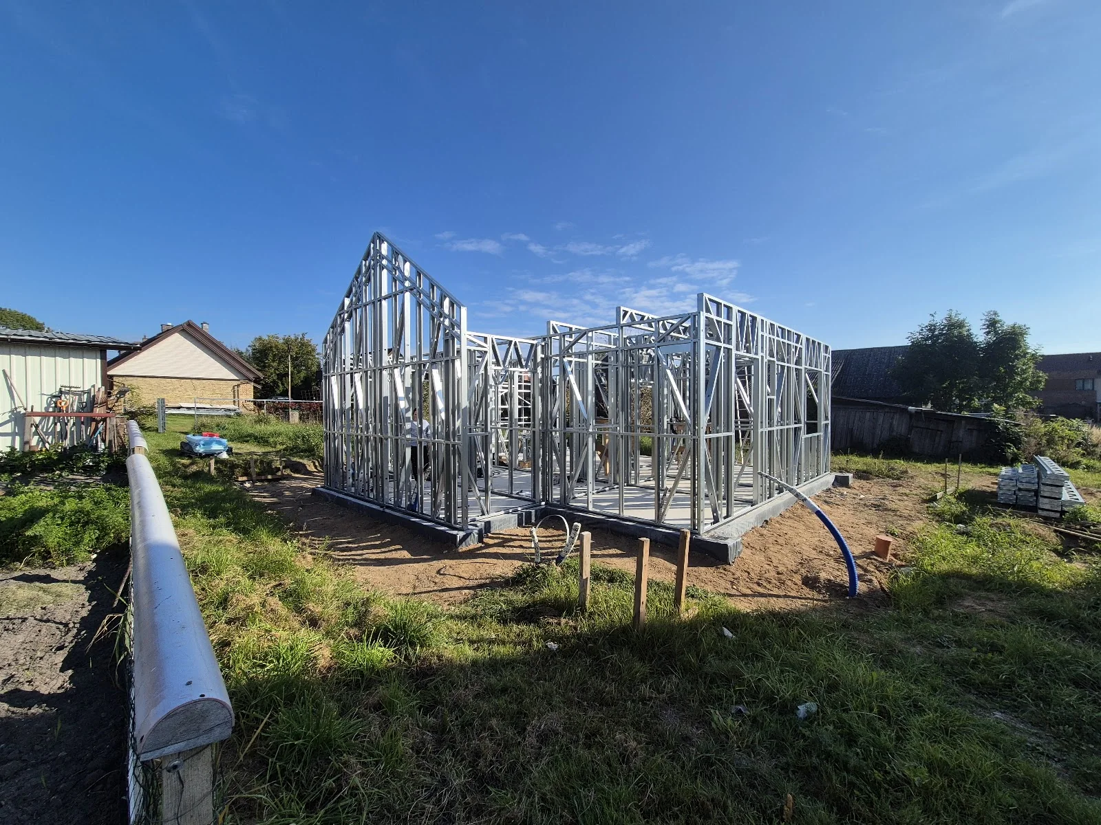 Maison LGS avec charpente à toiture complexe montée sur chantier, vue 1